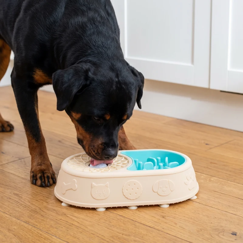 Un rottweiler qui lèche la boule sur le côté apaisant de la gamelle